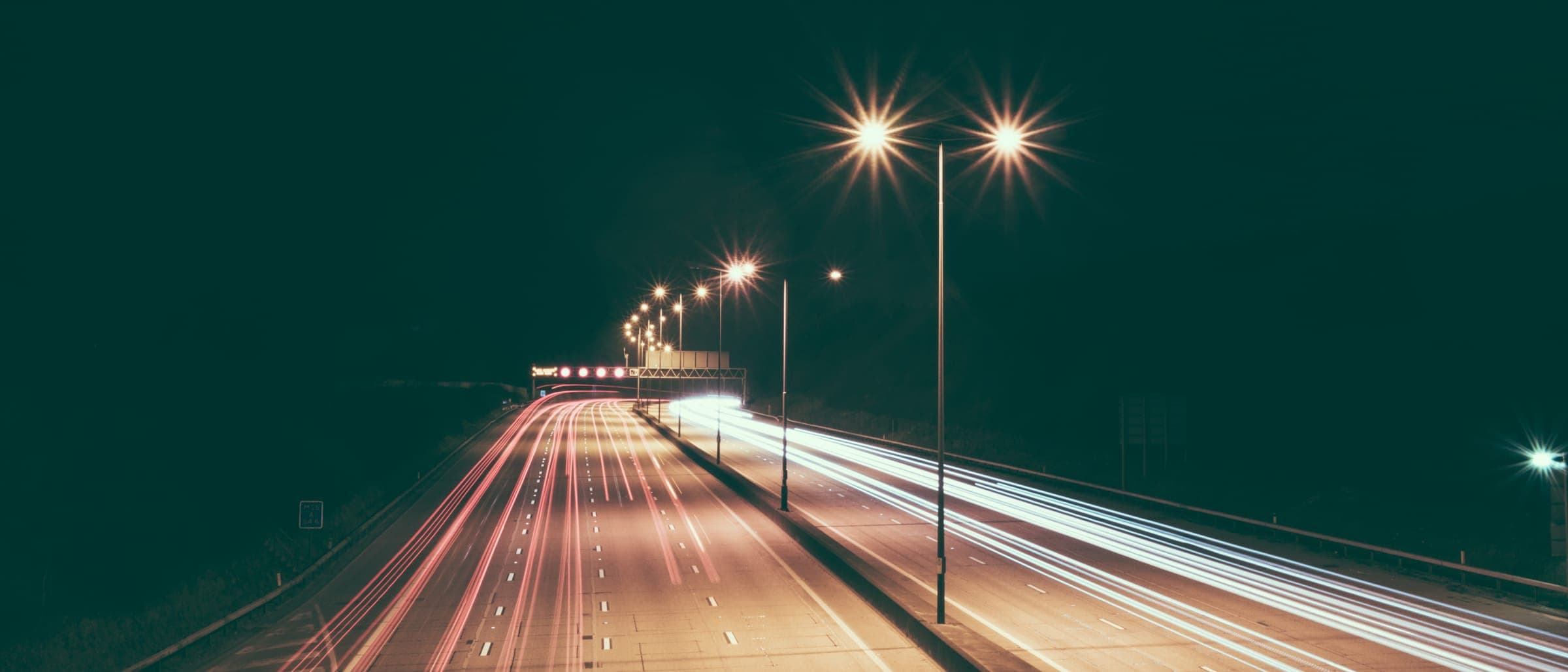 夜の道路と、車の光が流れた帯